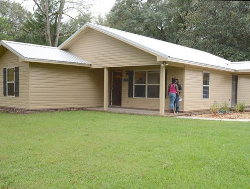 Two people in front of Habitat Chipola's new home