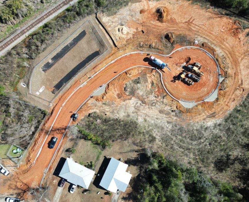 An aerial view of a development under construction. There is the outline of a street with curbs in place and the start of seven driveways